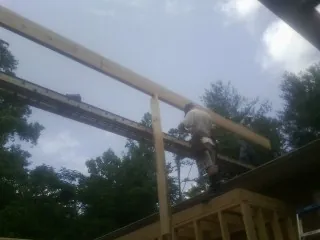 Carpenter setting a ridge beam over a new addition frame — Ice Dam Removal by Roofing Brothers in Kanaranzi